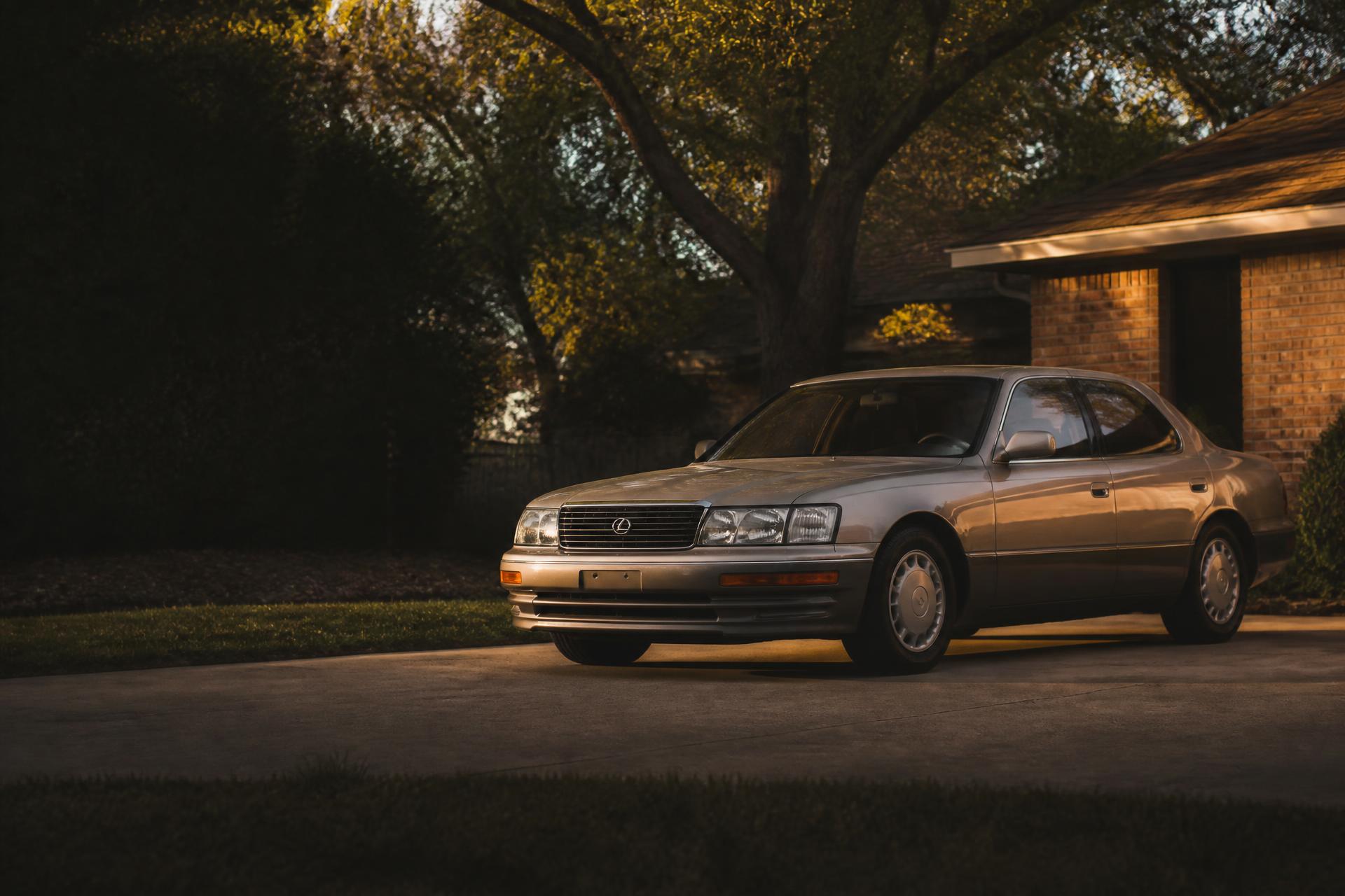 A well-kept used sedan parked in a residential driveway at golden hour